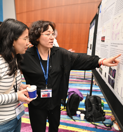 Two people looking at a poster